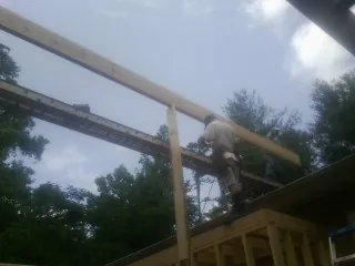 Carpenter setting a ridge beam over a new addition frame — Ice Dam Removal by Roofing Brothers in Pennsville