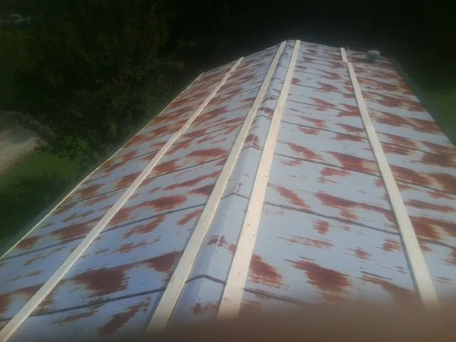 Rusted metal roof panels with new wood purlins before replacement — Storm Damage Roof Repair in Pennsville by Roofing Brothers
