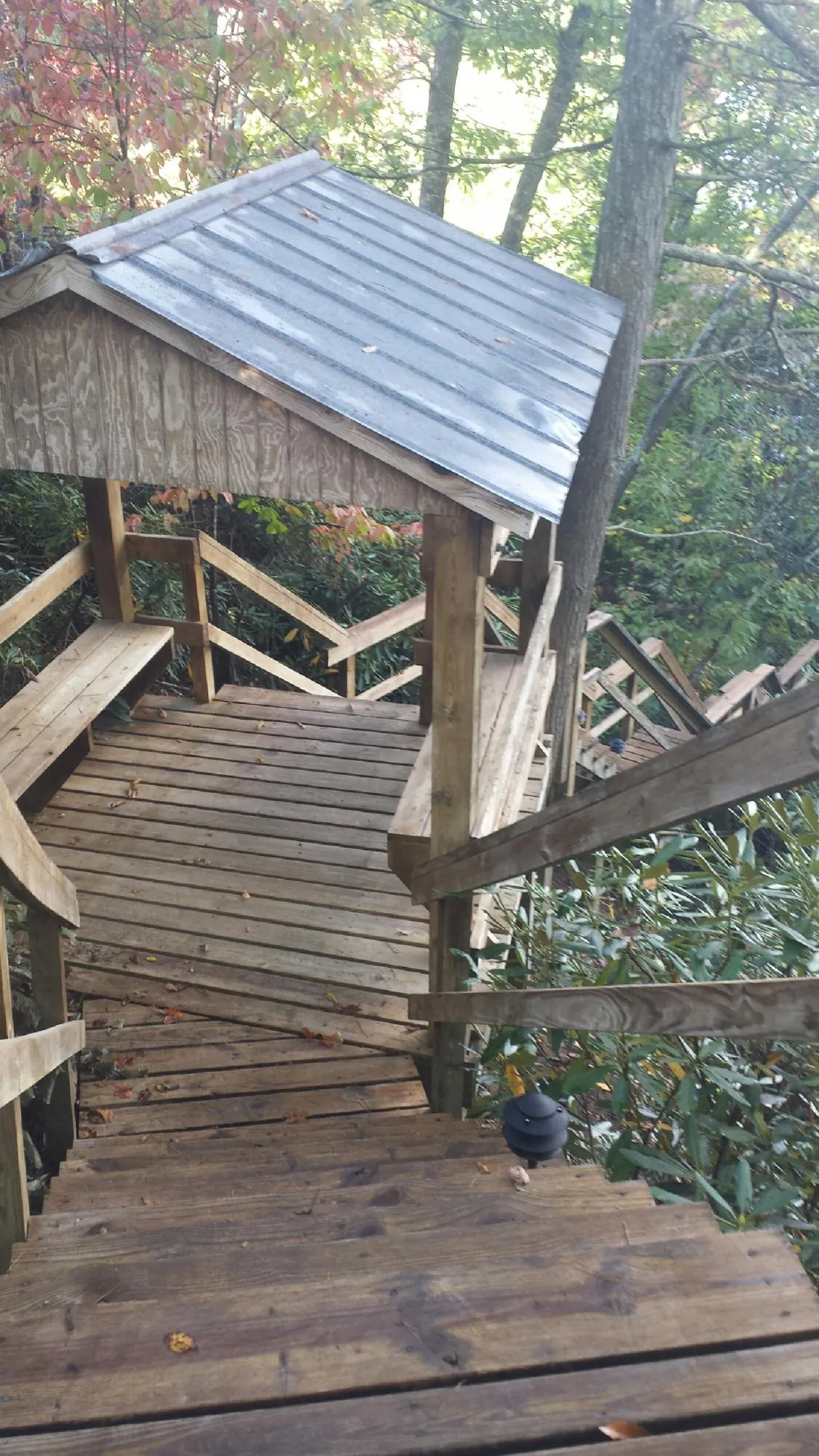Metal roofed shelter over wooden steps on a wooded walkway — Skylight Repair & Installation work by our crew in Pennsville